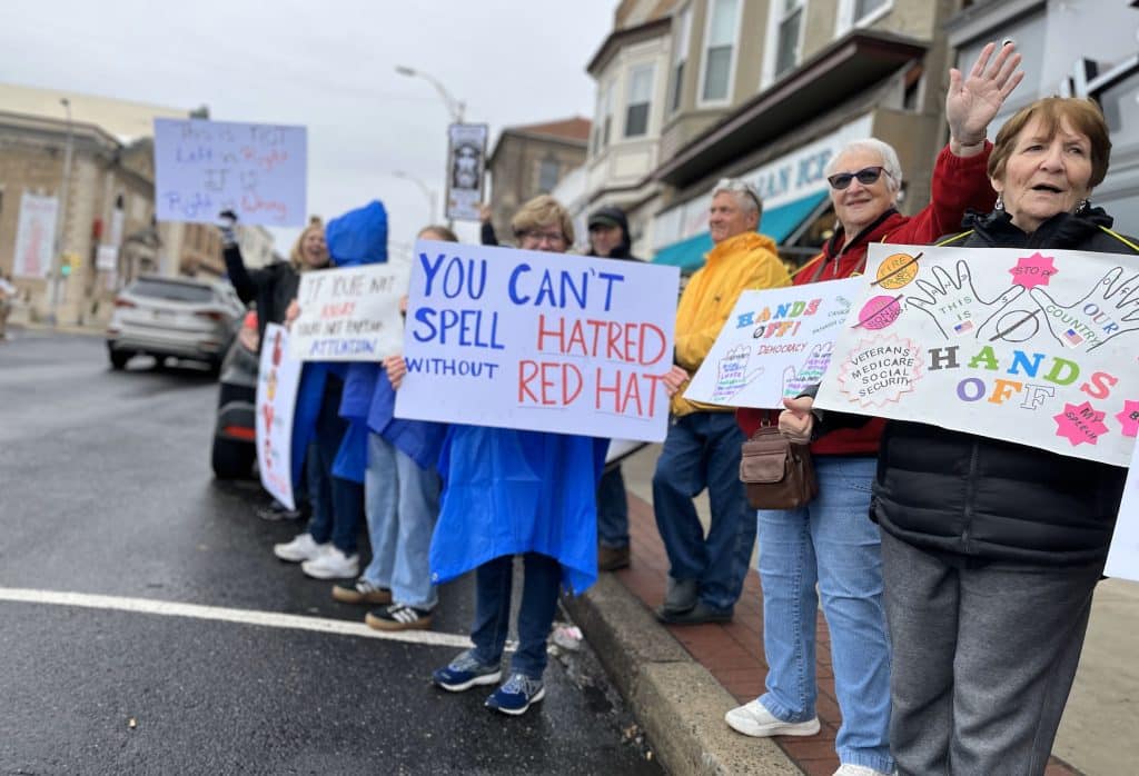 Street View 3 Elderly Ladies with Hands Off Medicare Social Security signs Red Hat sign 1 - Bucks County Beacon - Photo Essay: ‘Hands Off’ Quakertown Rally Draws 1,000 Protesters
